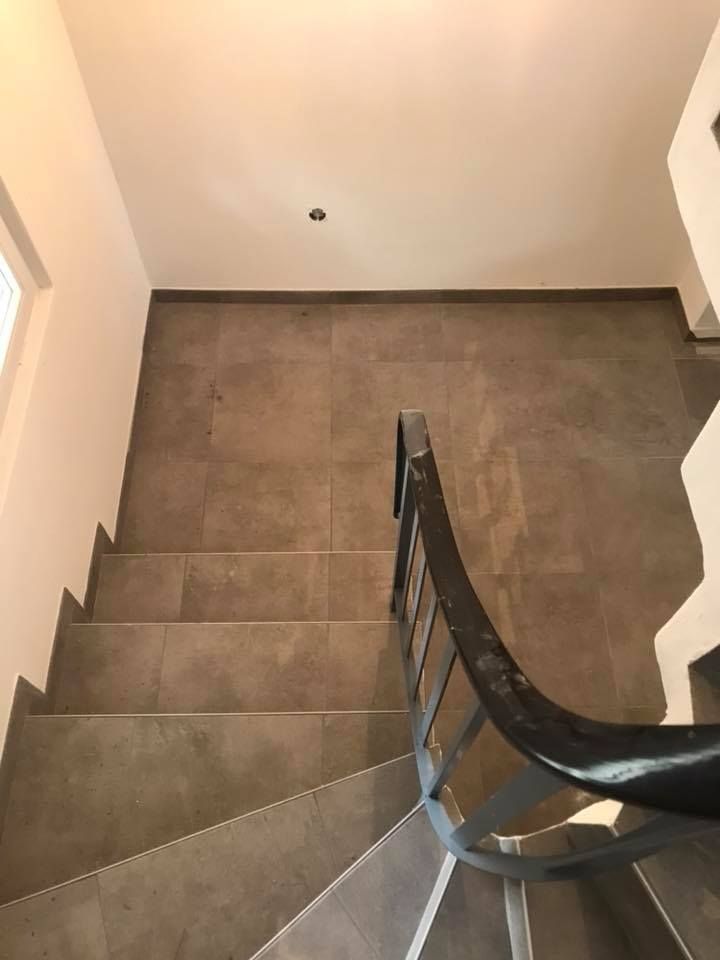 Escalier intérieur carrelé en grès cérame effet béton, nez de marche ajustés