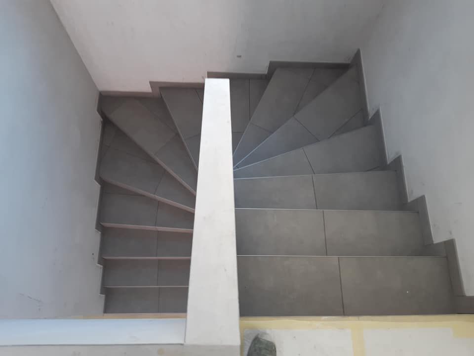 Escalier tournant entièrement carrelé, marches balancées en grand format